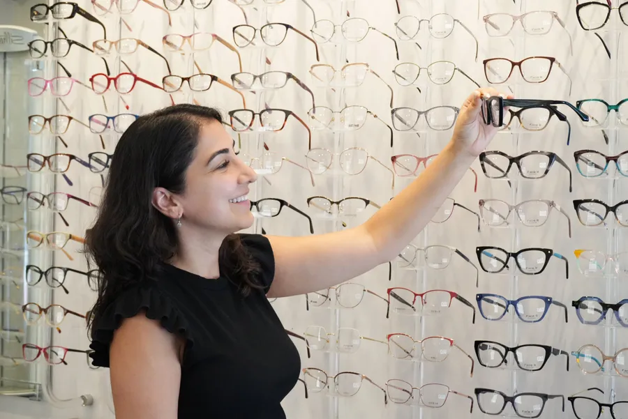 An optician assisting a customer with frame selection